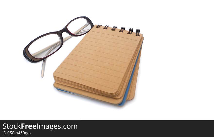 Notebook with glasses isolated on white