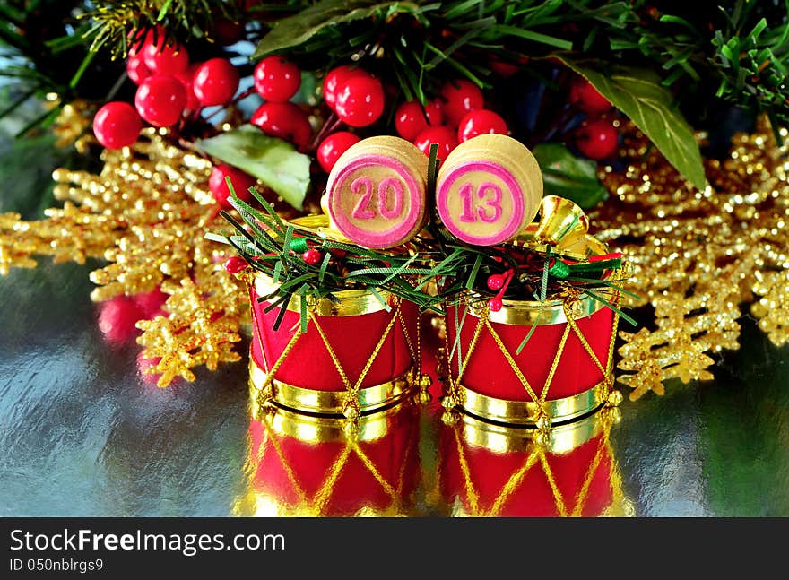 An image of wooden bingo kegs with numbers of coming new year against branch of christmas tree