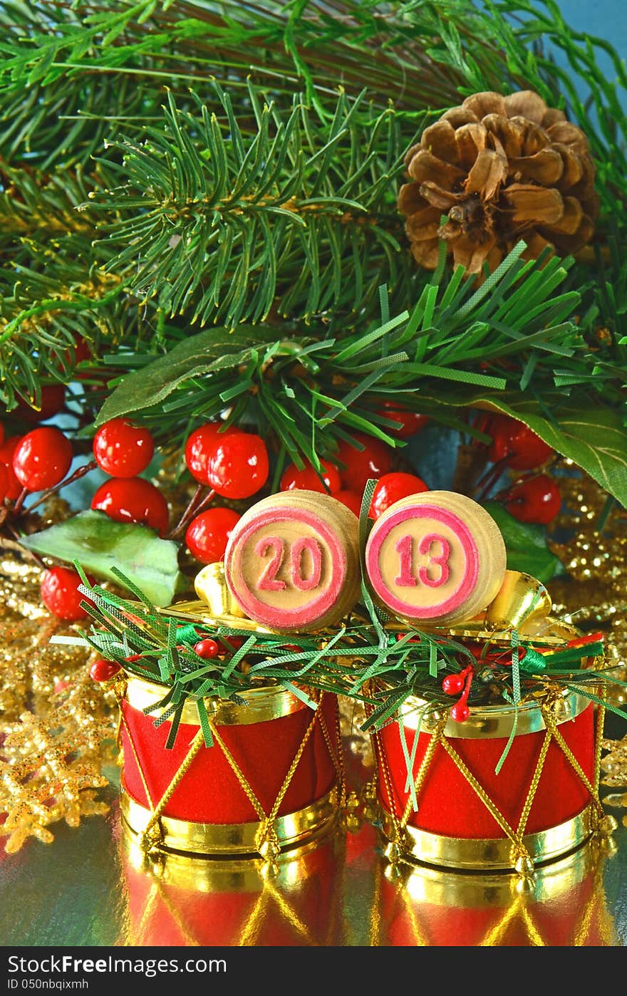 An image of wooden bingo kegs with numbers of coming new year against branch of christmas tree