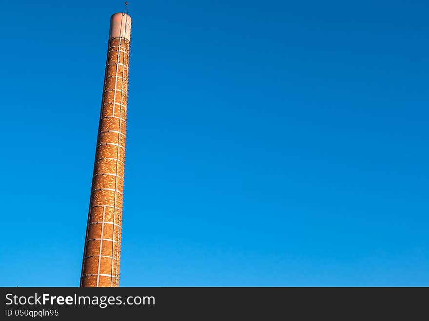 Factory plant industry chimney with clear blue sky behind - Industry background image