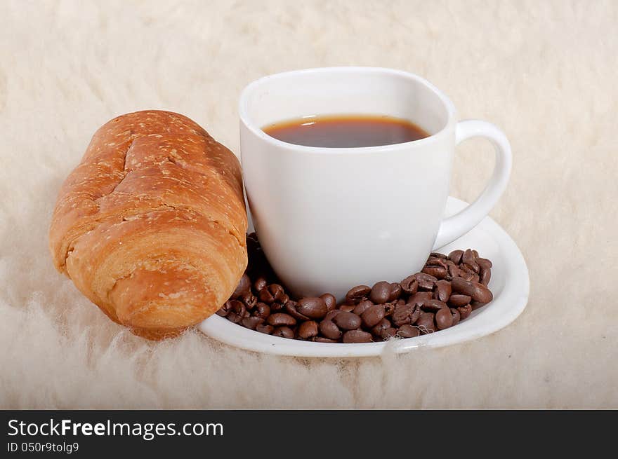 Croissant With Coffee And Beans On Fur Background