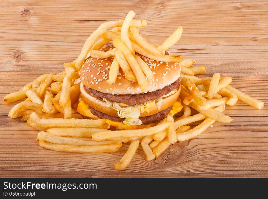 Hamburger and french fries on wooden background.