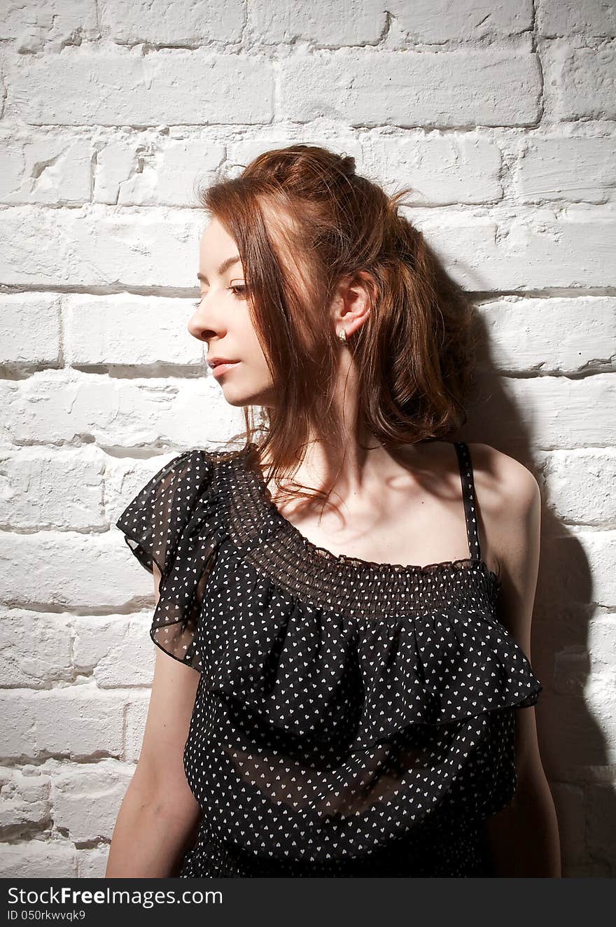 Portrait of Young Woman Looking Away on white brick background