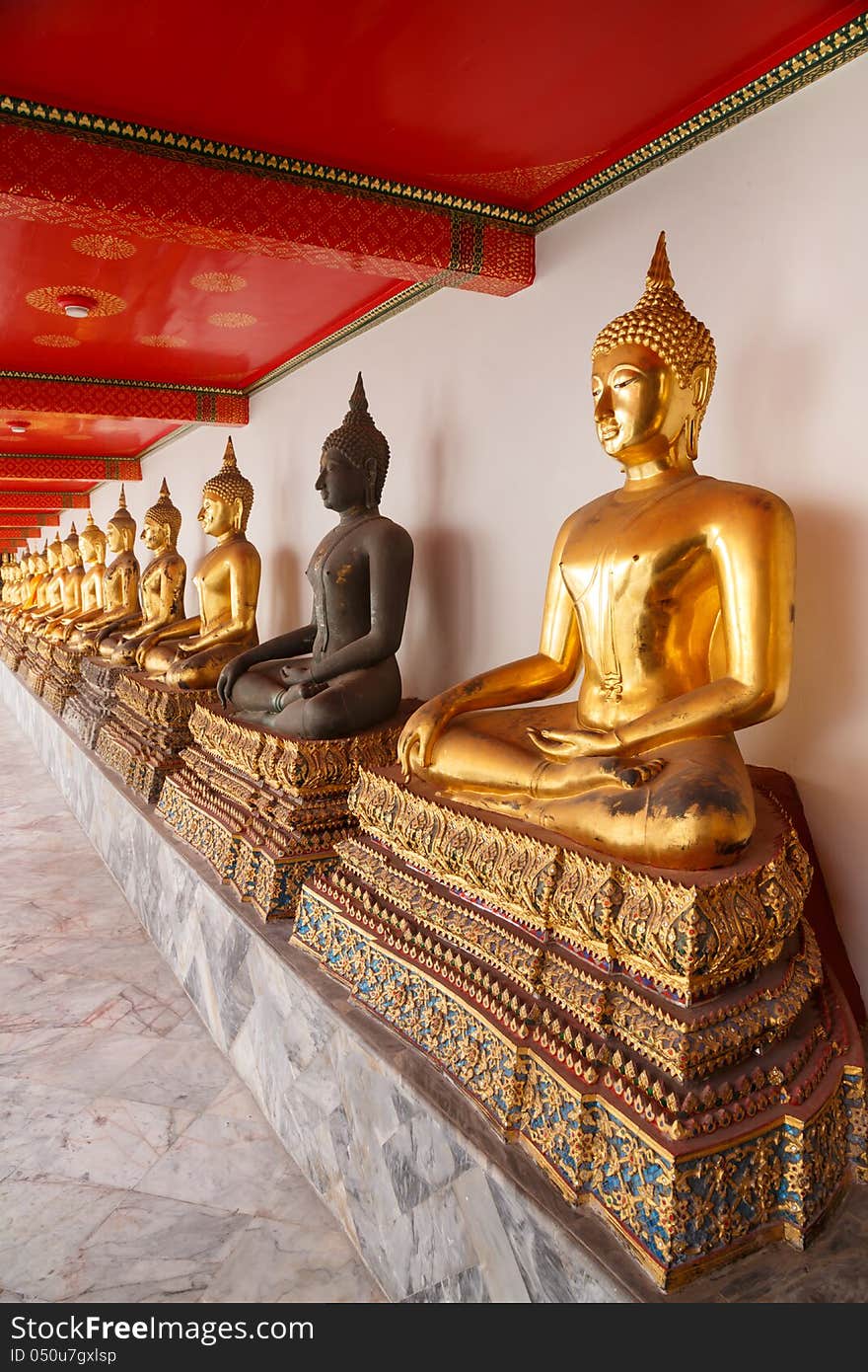 Buddha statues made of gold and black brass is line in a row temples in thailand