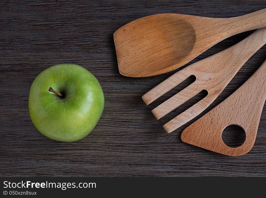 Green apple and kitchen wooden shovels