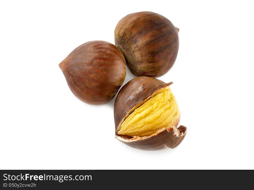 Fresh whole autumn chestnuts with one having its shell split and peeled back to expose the kernel on a white background