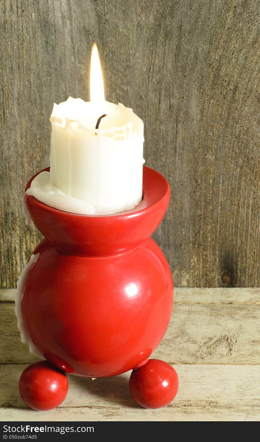 Red and round traditional candle holder with burning candle. Red and round traditional candle holder with burning candle