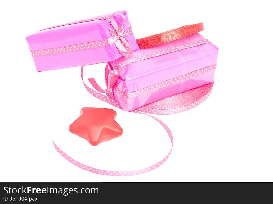 Two wrapped gifts arranged with blocks of pink and red ribbon and a decoration star (isolated). Two wrapped gifts arranged with blocks of pink and red ribbon and a decoration star (isolated)