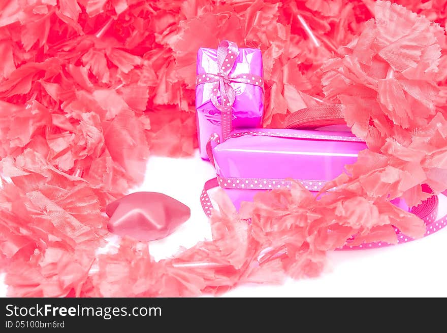 Pair of wrapped gifts on the background of red and pink synthetic petals. Pair of wrapped gifts on the background of red and pink synthetic petals