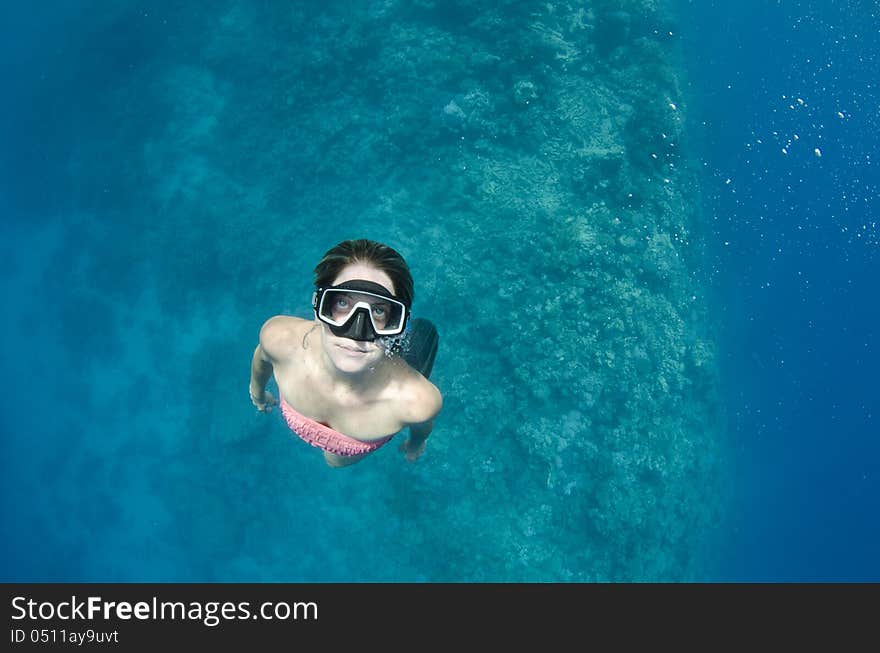 Woman free diving on a coral reef