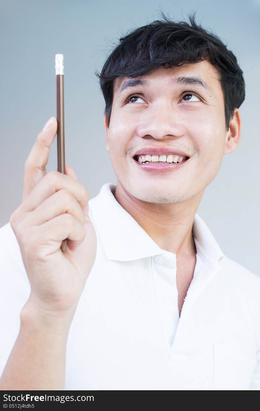 Asian Student  Looking Up And Holding Pencil,With Copyspace For Ideas And Concept. Asian Student  Looking Up And Holding Pencil,With Copyspace For Ideas And Concept