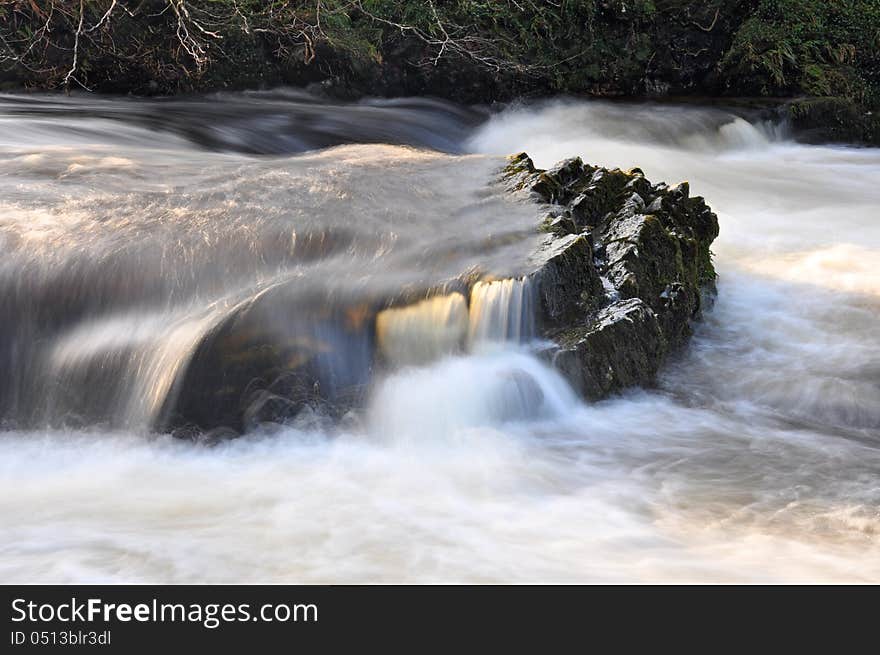 Swollen river with swirling water over rocks. Swollen river with swirling water over rocks