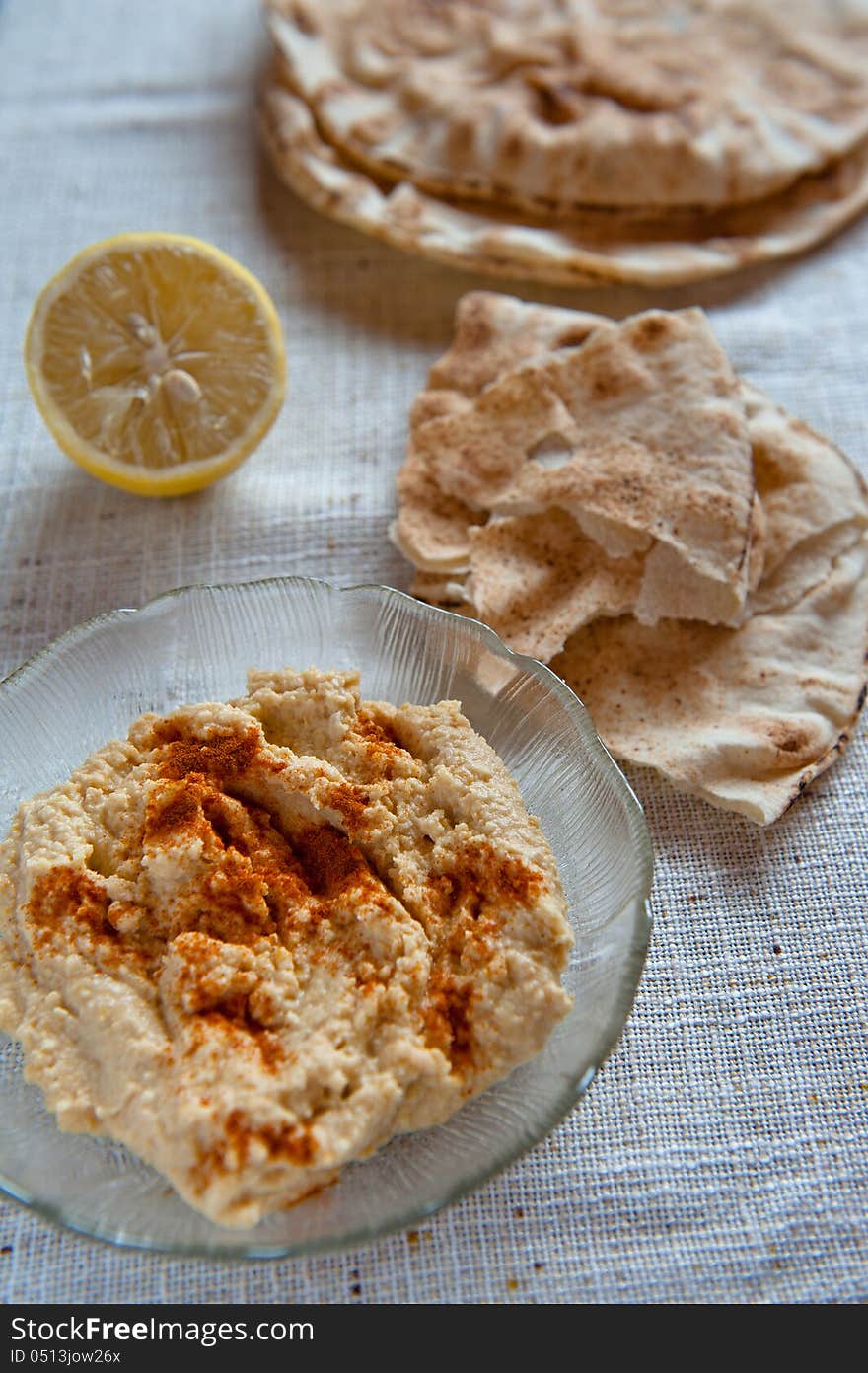 Dish of hummus with pita bread and paprika