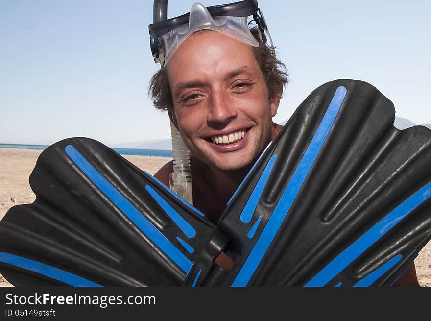 Man on a beach with mask and finns about to go swimming and snorkeling. Man on a beach with mask and finns about to go swimming and snorkeling