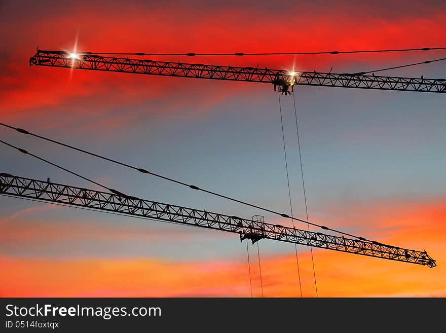 Construction cranes on sunset bright background. Construction cranes on sunset bright background