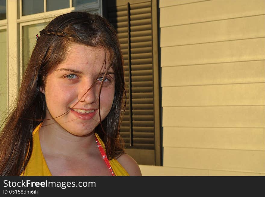 A young American teen is smiling during a sunrise in Cape Cod. A young American teen is smiling during a sunrise in Cape Cod