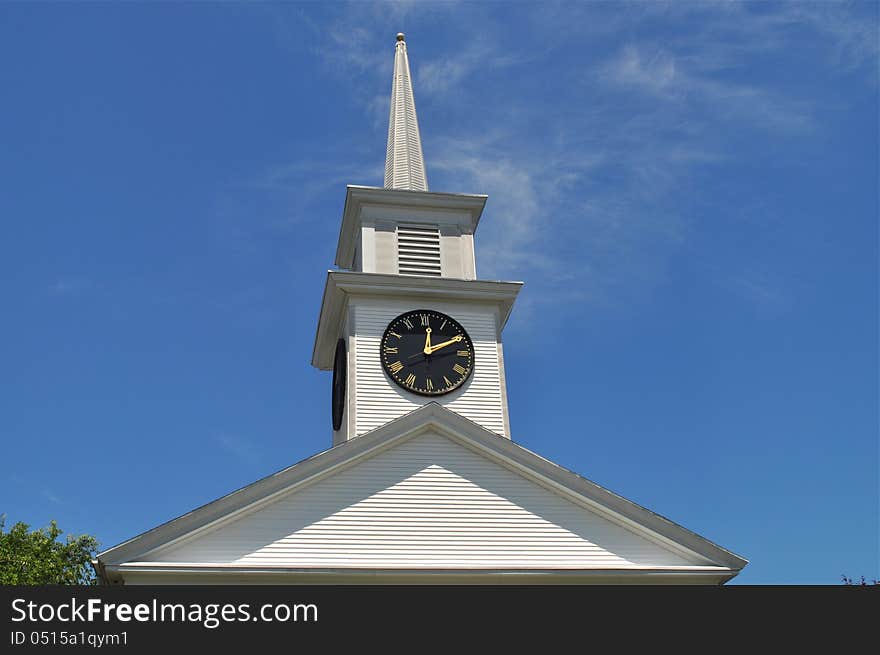 A magnificent tower clock with a blue sky background. A magnificent tower clock with a blue sky background