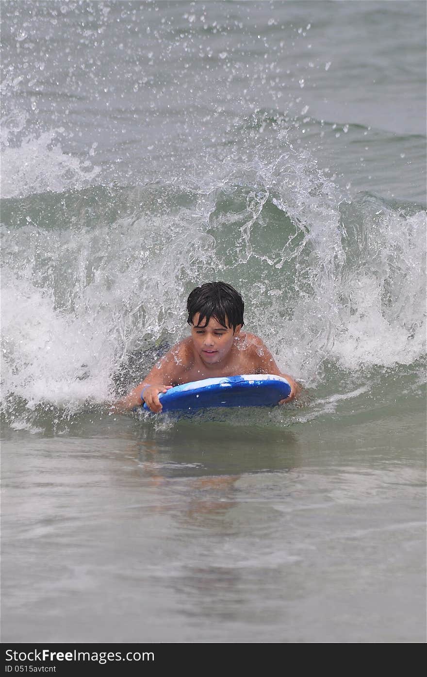 A boy is enjoying at the beach during a summer day. A boy is enjoying at the beach during a summer day.