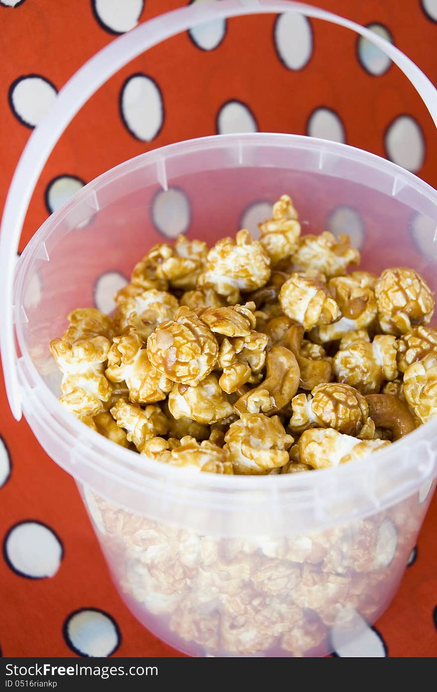 Close up caramel popcorn in bucket with red background