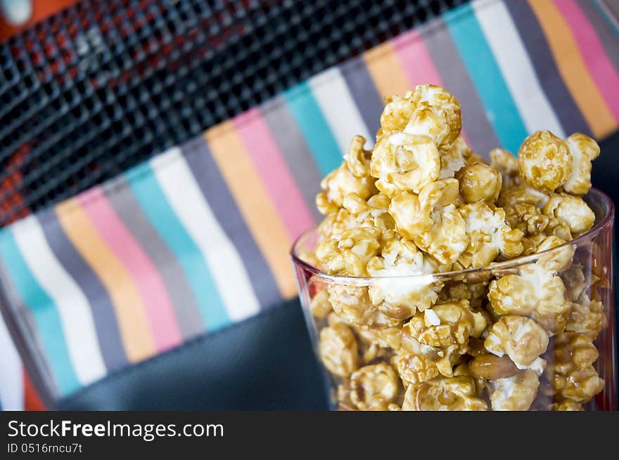 Clsoe up caramel popcorn in glass with corlorful background