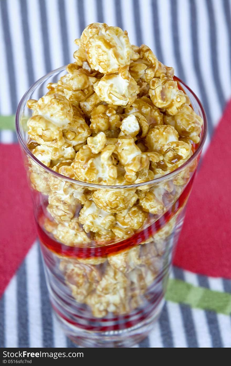 Caramel popcorn in glass with colorful background. Caramel popcorn in glass with colorful background