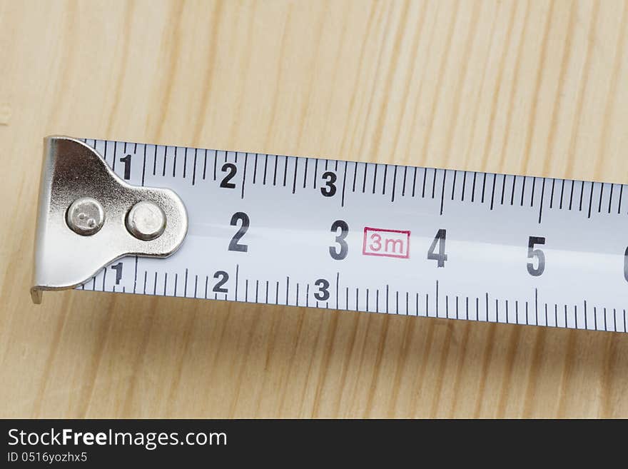 Tape measure closeup on wood background