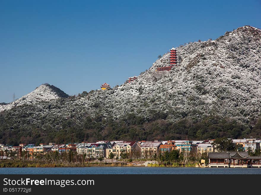 View from Xiang Lake, snow covered hill, village's houses, and color temple in the hill. View from Xiang Lake, snow covered hill, village's houses, and color temple in the hill.