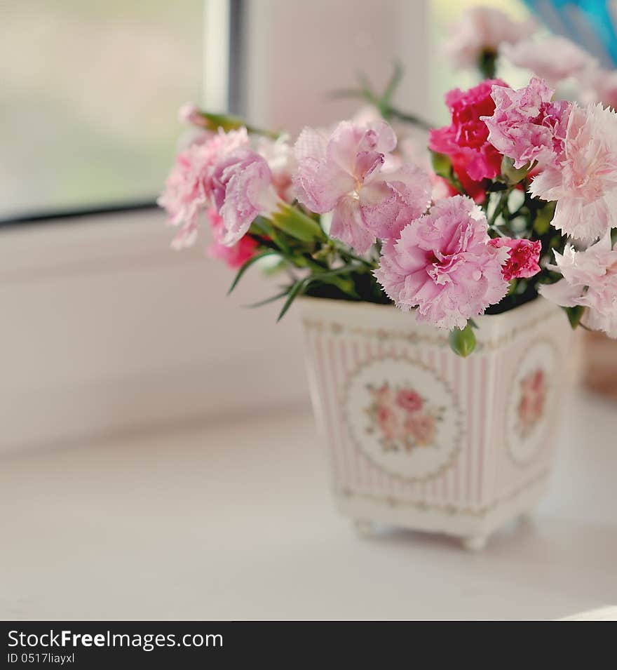 Beautiful fine bouquet of beautiful roses and carnations in a white pot. Beautiful fine bouquet of beautiful roses and carnations in a white pot