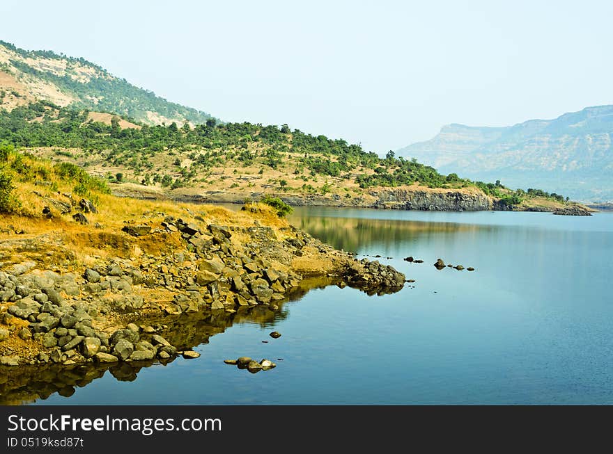 Lake at the foothills of the Sahyadri Hills in a winter midday, Karjat, Maharashtra, India. The water is so clean and transparent. Lake at the foothills of the Sahyadri Hills in a winter midday, Karjat, Maharashtra, India. The water is so clean and transparent.