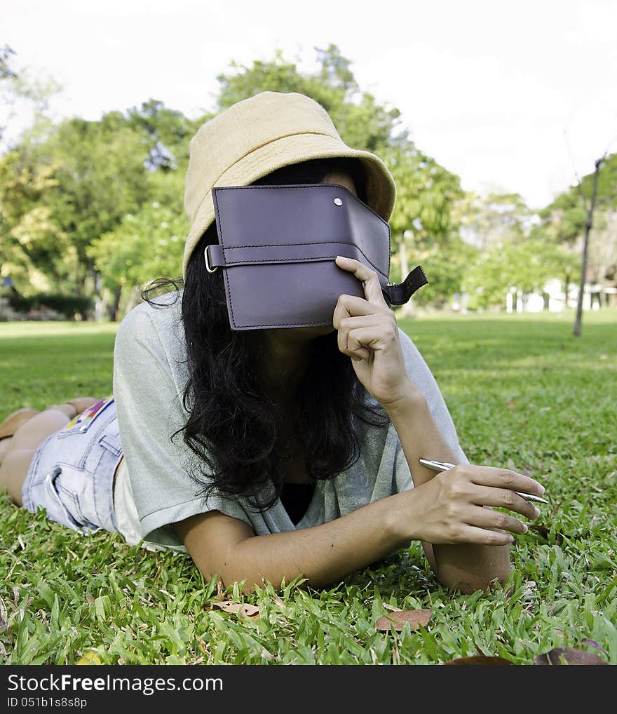 Woman laying on grass and thinking in park, outdoor