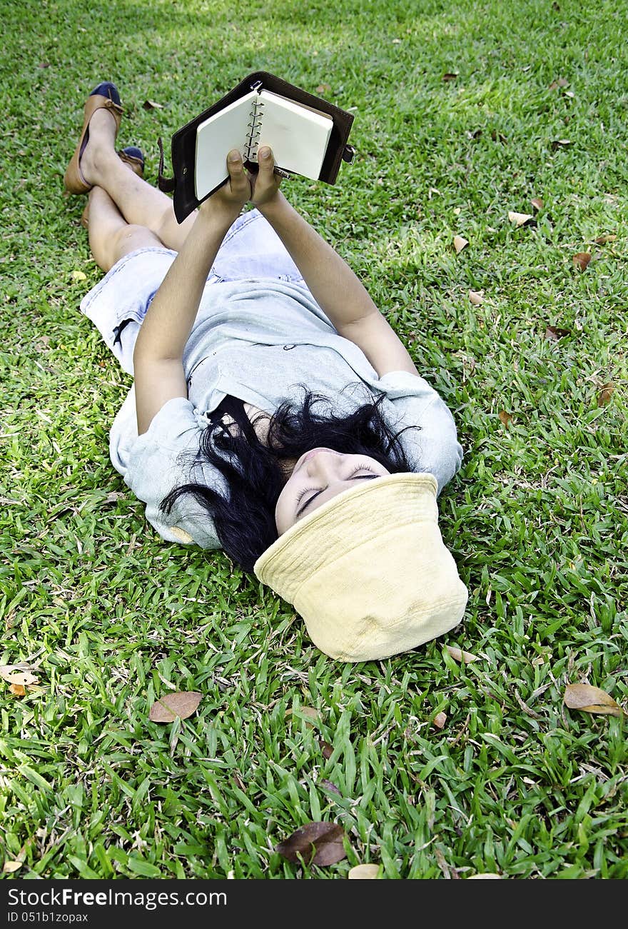 Young woman reading a book in park