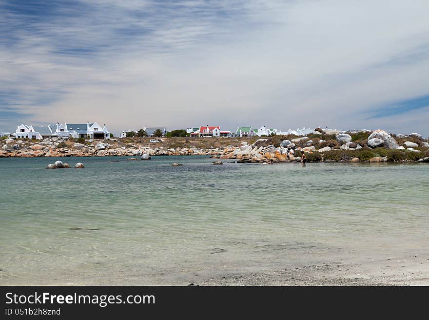 Clear water with fisherman house in the background, kids playing in the water. Clear water with fisherman house in the background, kids playing in the water