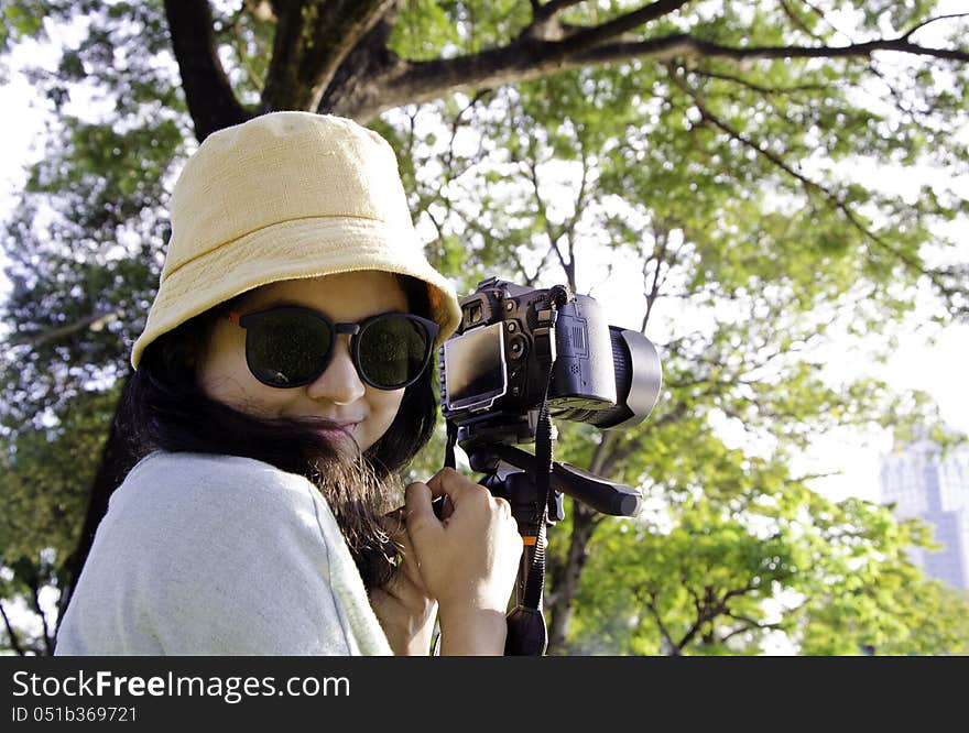 Smiling girl with camera on nature.