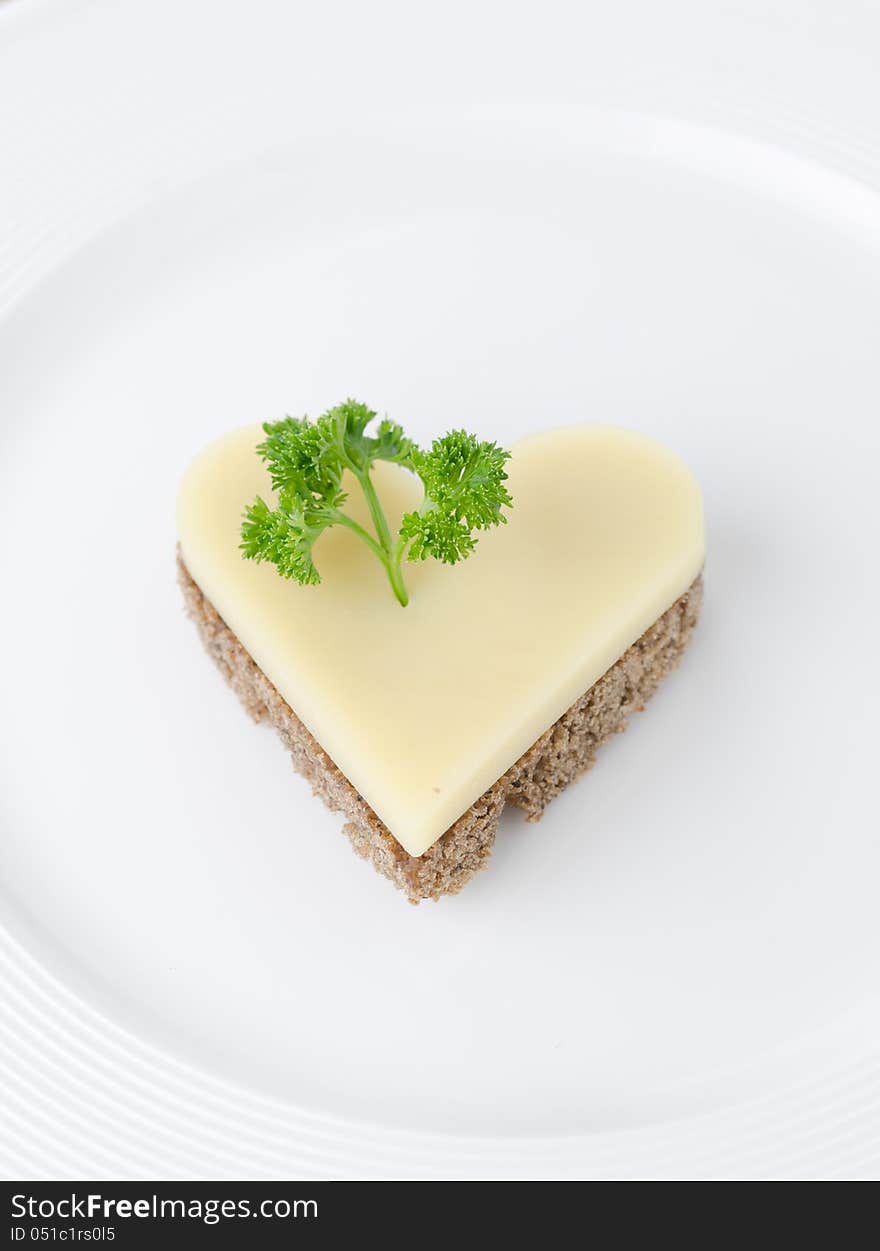 Appetizer with bread and cheese in the shape of heart on a white plate