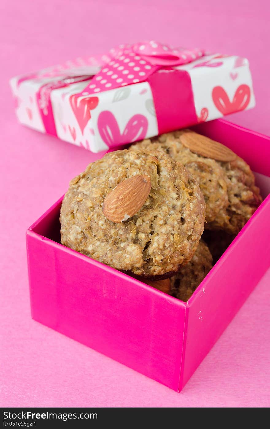 Gift box with homemade oatmeal cookies on a pink background