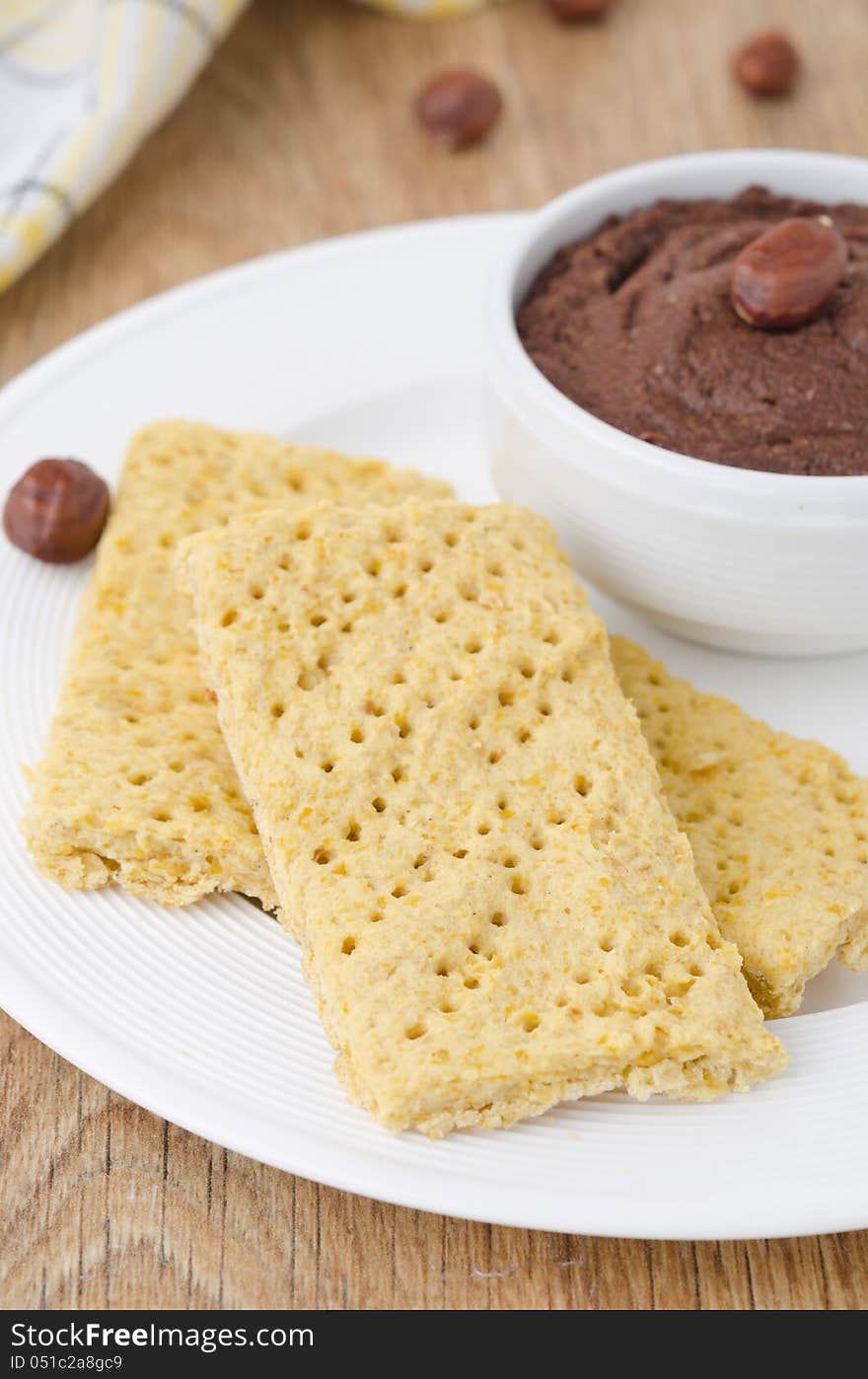 Homemade crackers and chocolate paste on a plate closeup. Homemade crackers and chocolate paste on a plate closeup