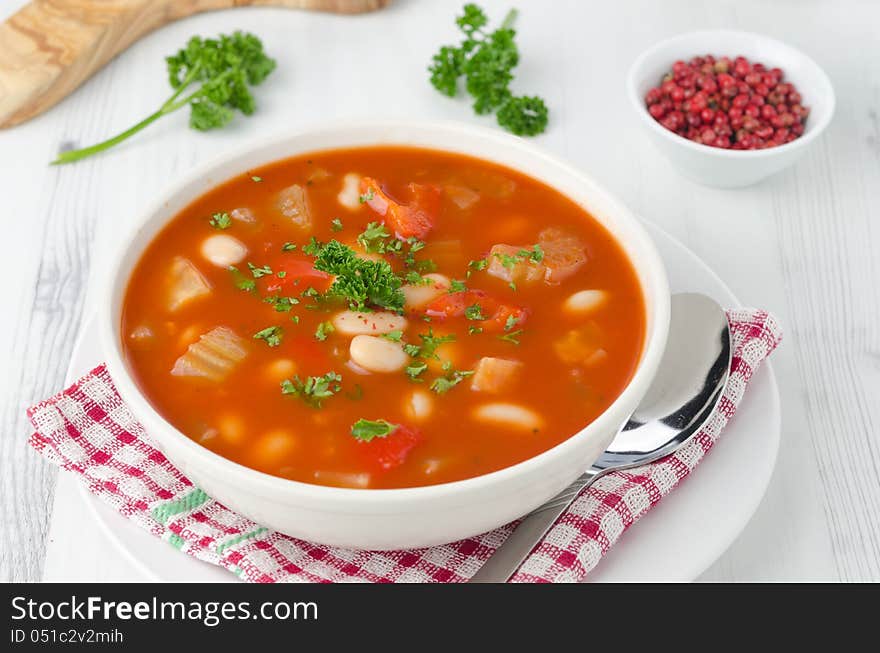 Bowl of roasted tomato soup with beans, celery and bell pepper