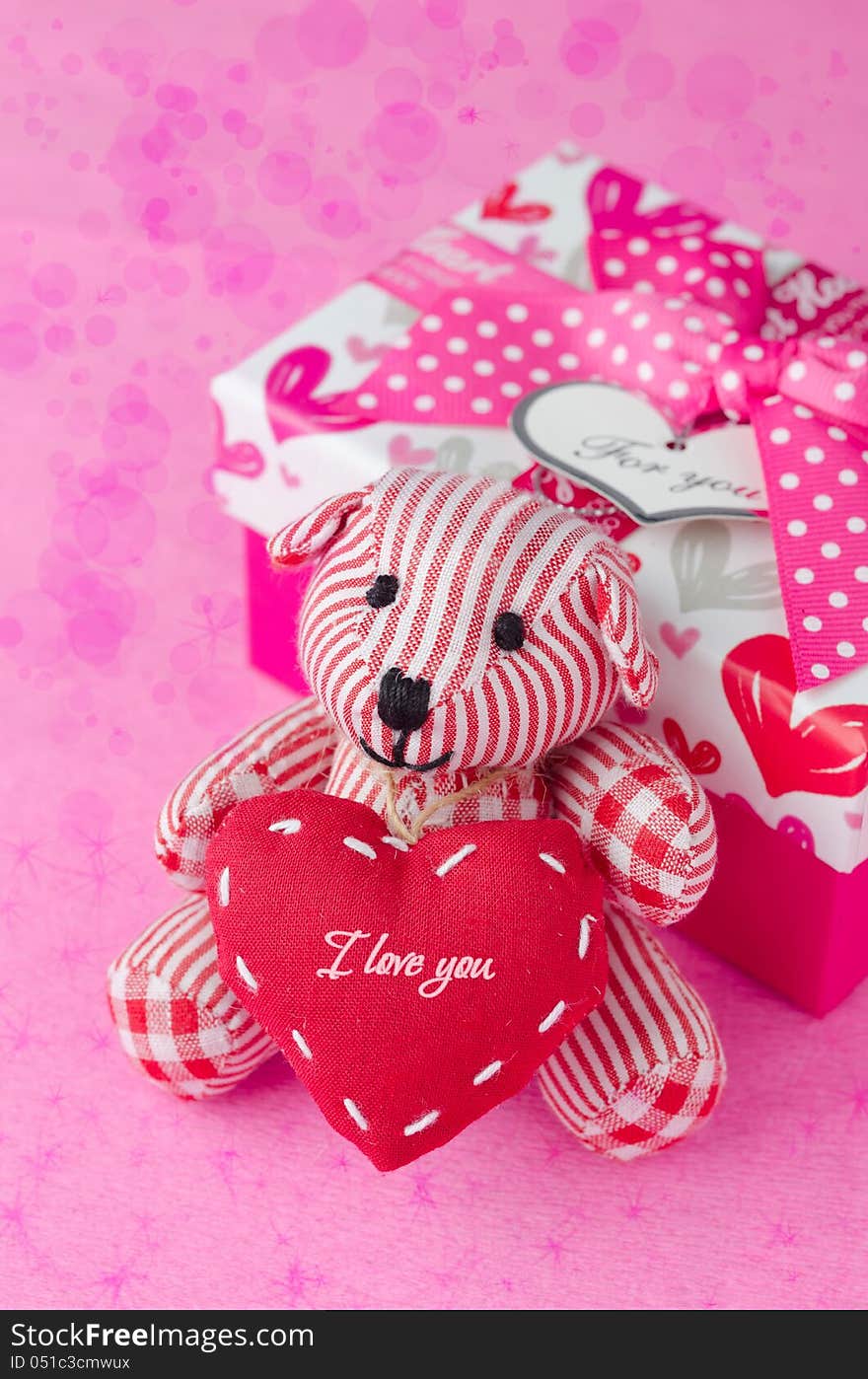 Teddy Bear With A Heart In The Hands Near A Gift Box And Bokeh