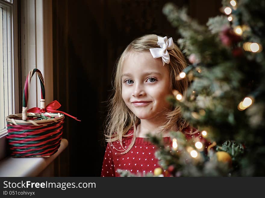 Little Girl Smiling Next to a Christmas Tree. Little Girl Smiling Next to a Christmas Tree