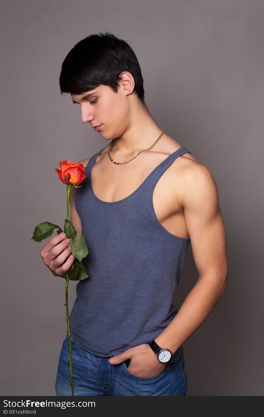 Muscular man with a rose in hands