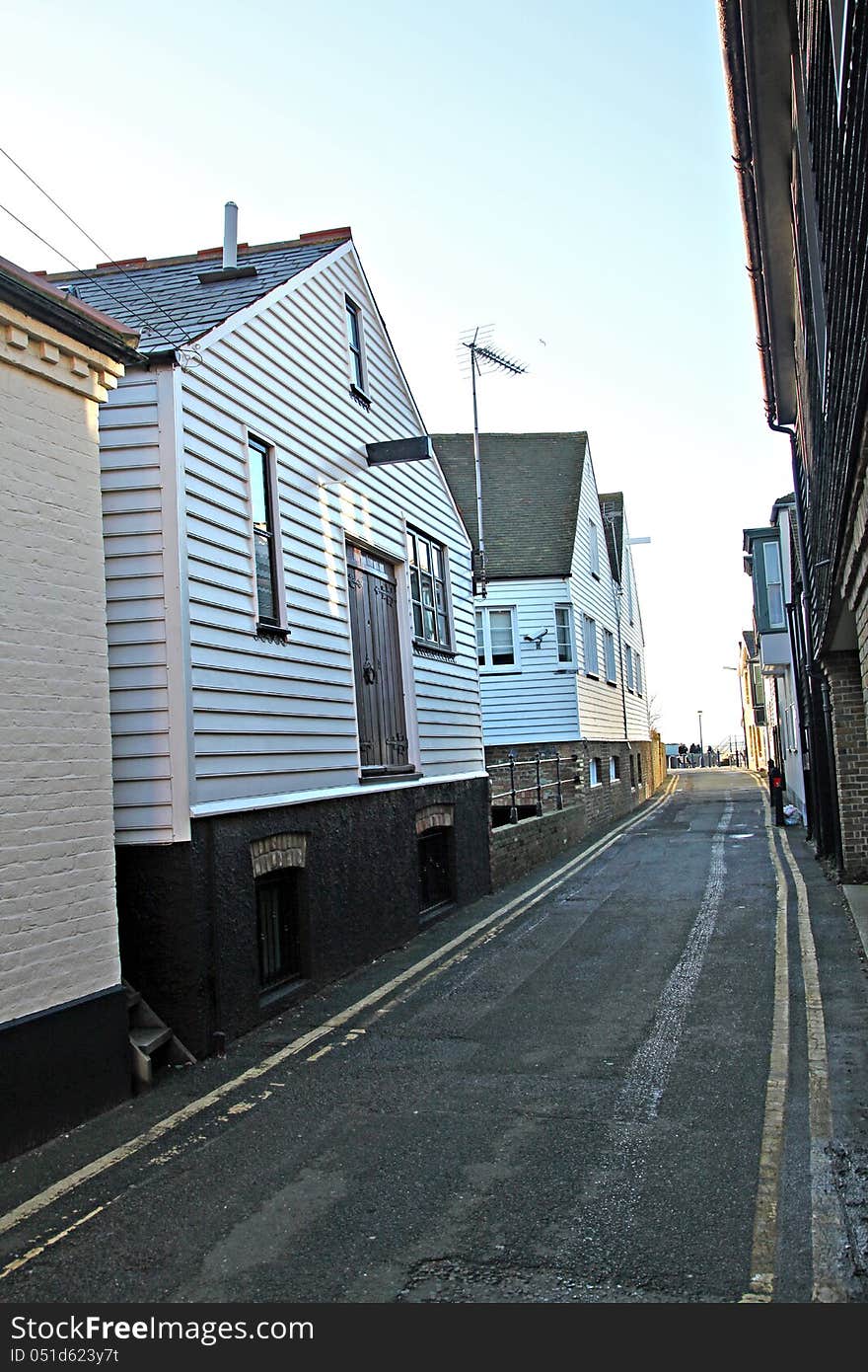 Photo showing narrow lane running between old fishermans huts and cottages in the historic harbour fishing town of whitstable in kent. Photo showing narrow lane running between old fishermans huts and cottages in the historic harbour fishing town of whitstable in kent.