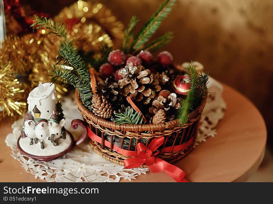 Christmas composition - a decorative candle and a basket with cones and grapes