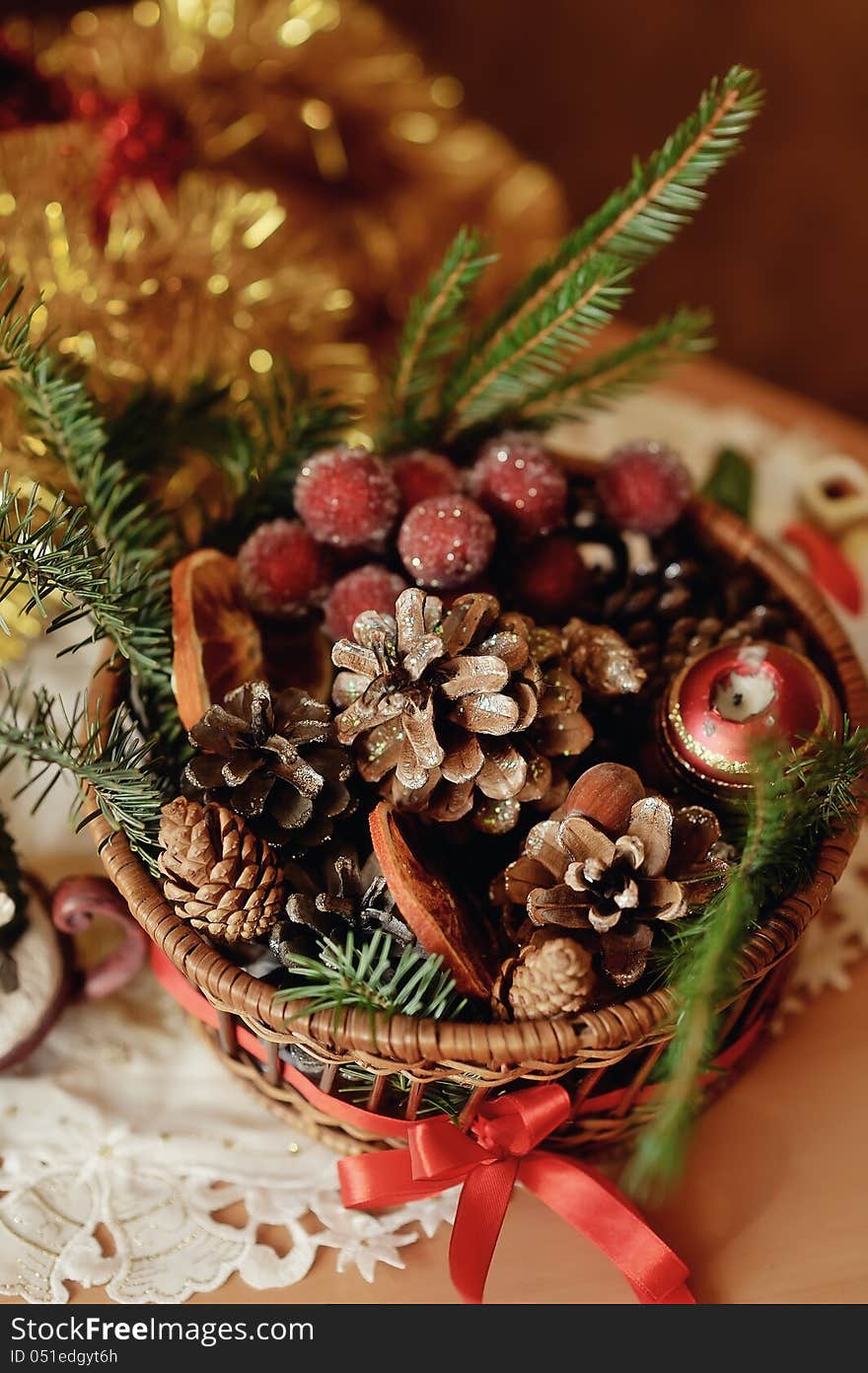 Christmas composition - a decorative candle and a basket with cones and grapes