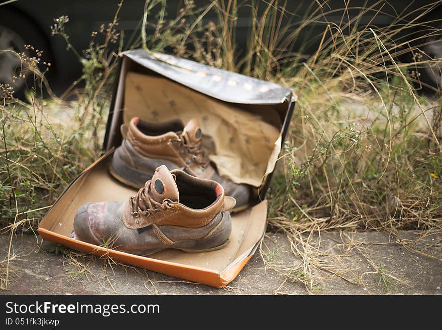 Worn hiking boots with box in grassland