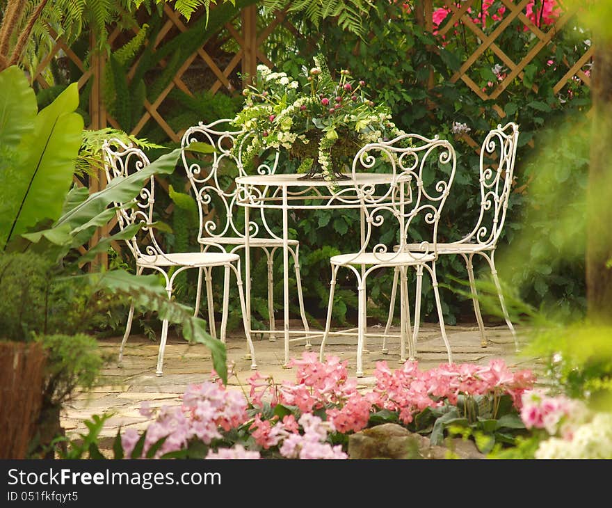 Chairs- A bunch of tropical flowers with an antique with table and 4 chairs. A romantic place with everything in perfect condition. royal conservatory in Brussels Belgium. Chairs- A bunch of tropical flowers with an antique with table and 4 chairs. A romantic place with everything in perfect condition. royal conservatory in Brussels Belgium.