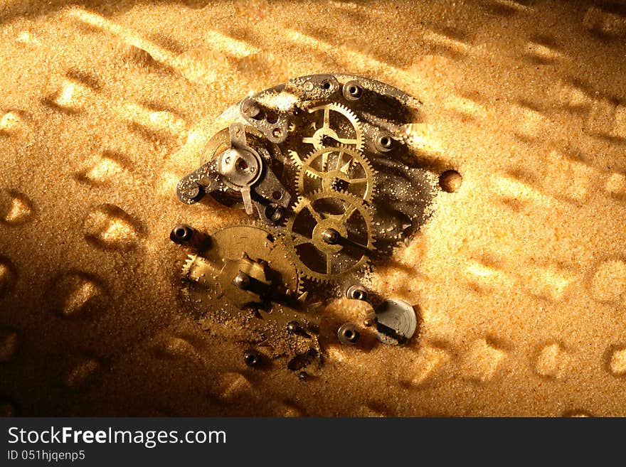 Business concept. Old clock mechanism on sand surface. Nice background. Business concept. Old clock mechanism on sand surface. Nice background