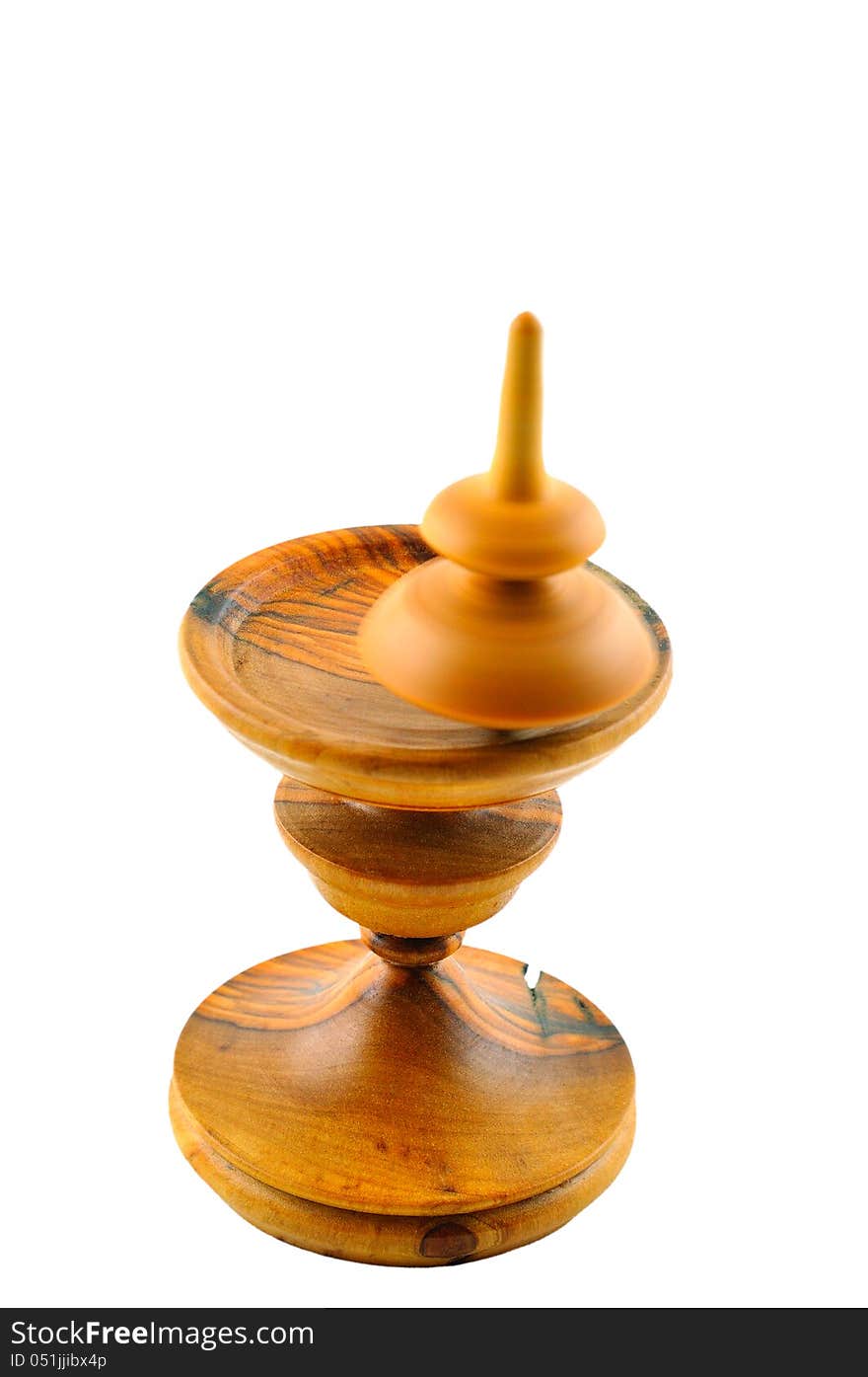 Spinning top made ​​of wood spinning on a special stand carved out of wood. Spinning top made ​​of wood spinning on a special stand carved out of wood