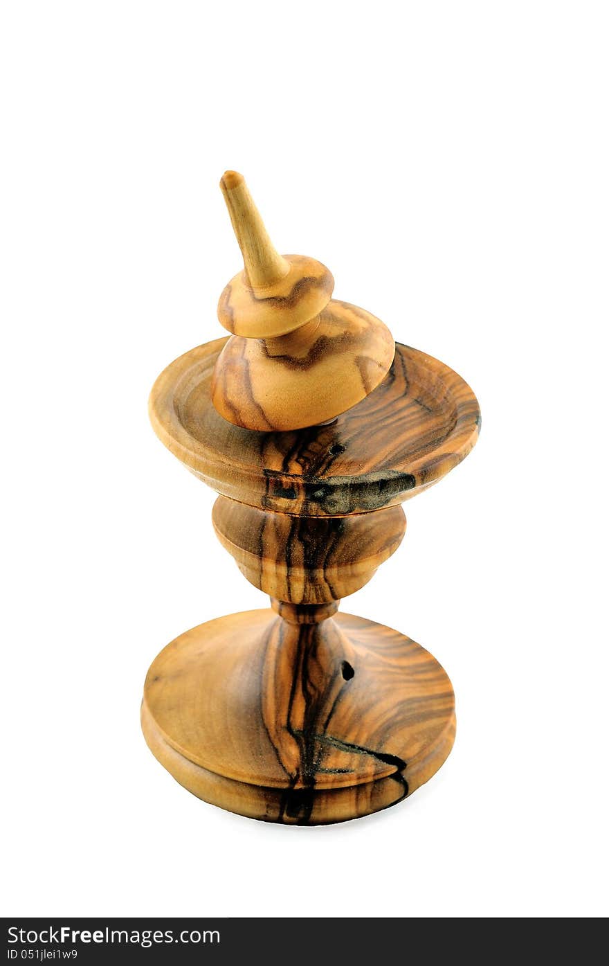 Spinning top made ​​of wood is on a special stand carved out of wood. Spinning top made ​​of wood is on a special stand carved out of wood