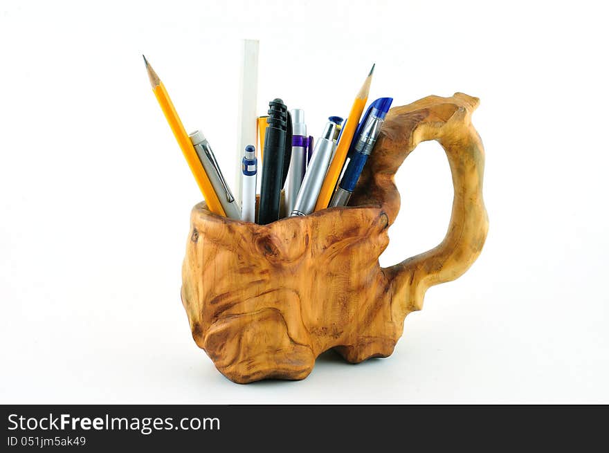 Wooden carved mug with pencils carved from wood and photographed against a white background