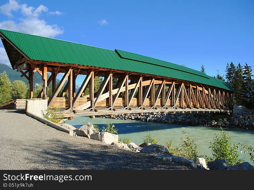 A wooden pedestrian bridge spanning the river to allow people to cross into town.